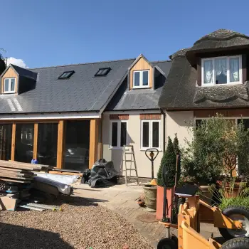 Steel clad in oak and glass two storey extension to a traditional thatched cottage in a conservation area: Click Here To View Larger Image